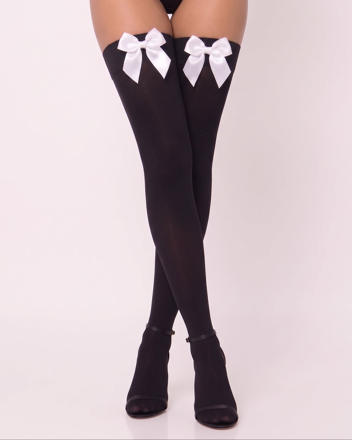 Black thigh-high stockings with large white satin bows at the top, shown on a model's legs against a plain light background.