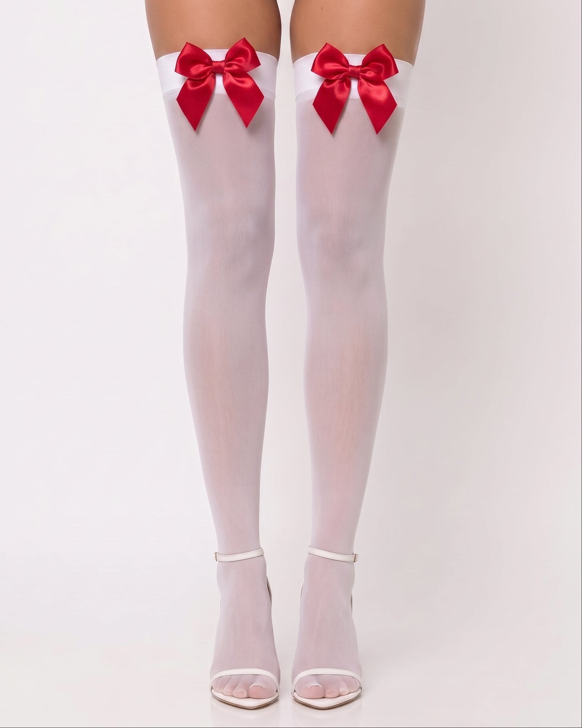 White thigh-high stockings with large red satin bows at the top, shown on a model's legs against a light gray studio background.